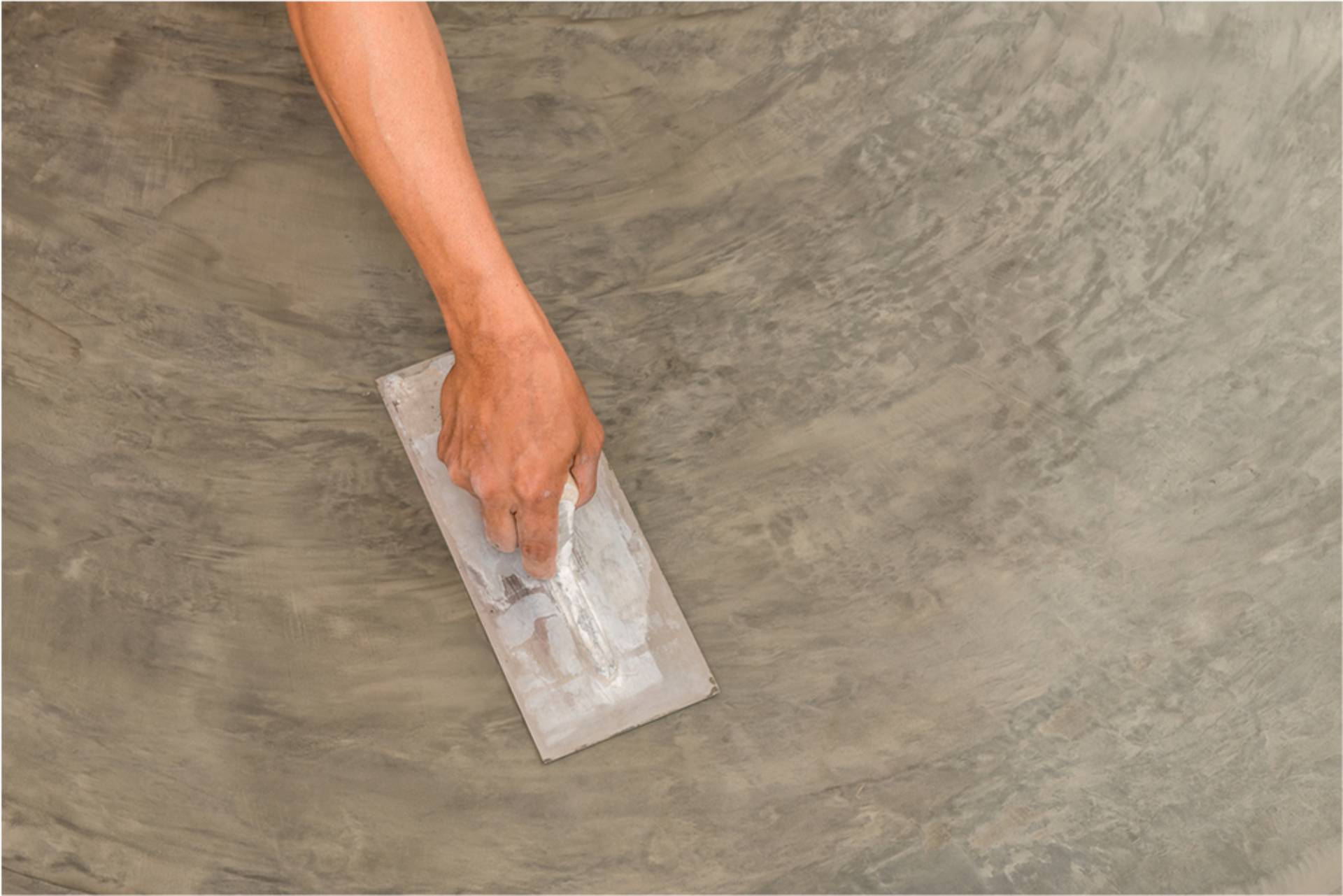 worker using a handtool to stain an area